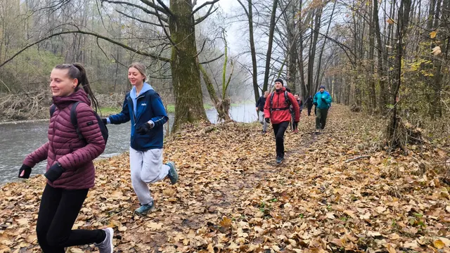 Skupina běžců na podzimní stezce u řeky