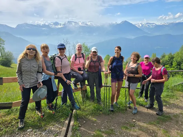 Skupina turistů na vyhlídce s horským panoramatem