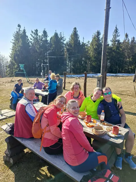 Skupina turistů při odpočinku u venkovního stolu