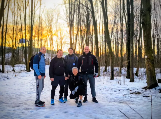 Společná fotografie běžců v zimním lese
