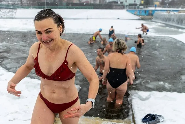 Otužilkyně vystupuje z Ostravice mezi ledovými krami